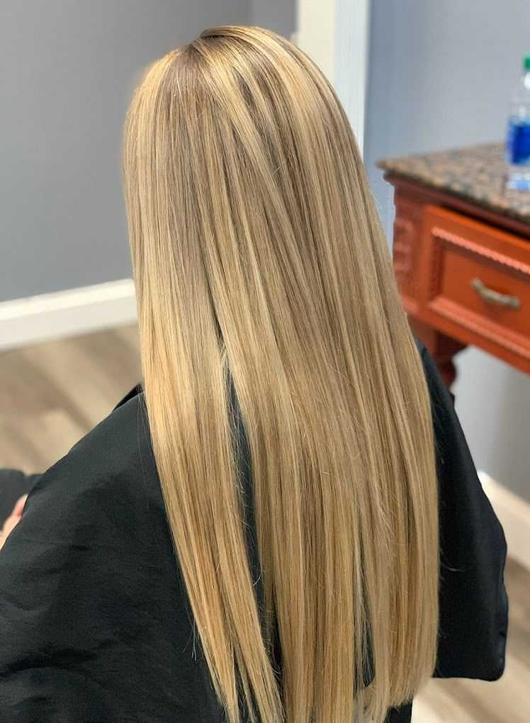 Blonde hair with straight highlights, viewed from the back in a salon setting.